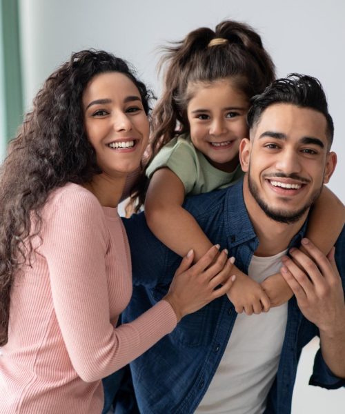 portraif-happy-young-arabic-family-three-with-little-daughter-middle-eastern-mom-dad-kid-having-fun-while-posing-home-parents-enjoying-spending-time-with-their-child-free-space